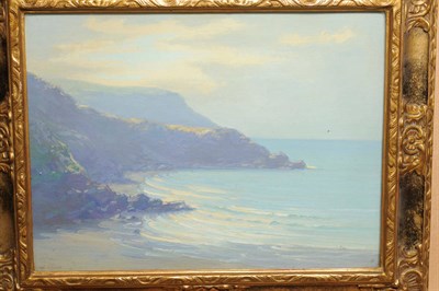 Lot 772 - Augustus William Ennes RBA (1876-1948) Sunlit coastal scene with a rocky cove and beach in the...