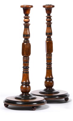 Lot 322 - A Pair of Turned Walnut and Ebonised Candlesticks, mid 19th century, with urn sconces, baluster...