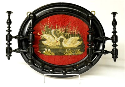 Lot 337 - A Victorian Ebonised Coat Hanger, the oval back set with a beadwork panel depicting two swans...