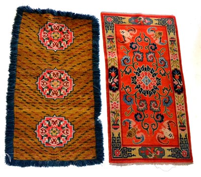 Lot 445 - Tibetan Rug The tangerine field of scrolling vines centred by a lotus flower, the spandrels...