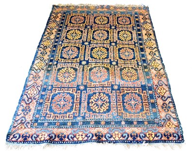 Lot 516 - Khotan Rug Chinese Turkestan The deep indigo compartmentalised field of stylised flowerheads...