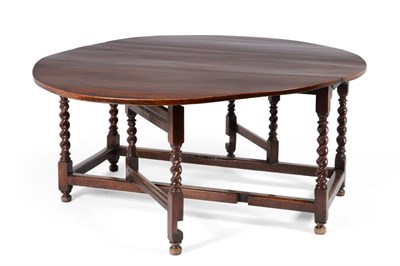 Lot 529 - A Large Walnut Gateleg Table, the oval top raised on twist-turned supports joined by plain...