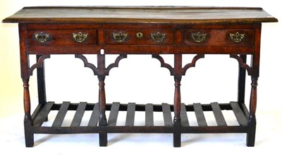 Lot 549 - A George III Oak Low Dresser, the top with a moulded edge over three frieze drawers, raised on...