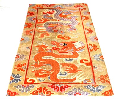 Lot 560 - Tibetan Rug The desert sand field with two fighting dragons enclosed by borders of stylised...