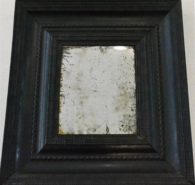 Lot 575 - An 18th Century Dutch Ebonised Wall Mirror, the rectangular plate in a stepped frame with wave...