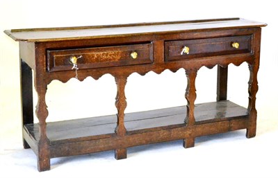 Lot 584 - A George III Oak Low Dresser, the rectangular top with cut corners, over two moulded-front drawers