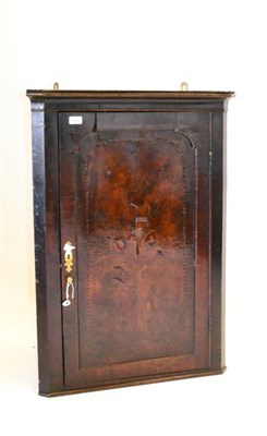 Lot 585 - A George II Walnut Veneered Hanging Corner Cupboard, with a coved cornice and arched panel door...