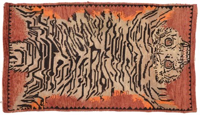 Lot 604 - Tibetan Tiger Rug The rust field depicting a semi-naturalistic tiger enclosed by narrow...