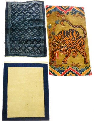 Lot 609 - Tibetan Tiger Rug The tan field with a roaring tiger in a landscape of bamboo, 164cm by 90cm;...