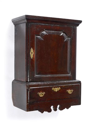 Lot 614 - A George II Oak Hanging Spice Cabinet, with a moulded cornice over a fielded panel door...