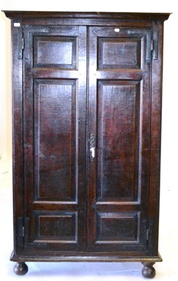 Lot 667 - A Large Oak Cupboard, with a moulded cornice over two panelled doors, hanging space within, on...