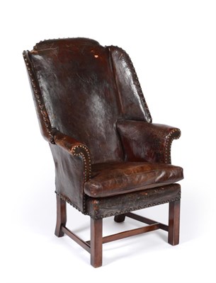 Lot 670 - A Small Wing Easy Chair, upholstered in dark brown leather, on square legs with stretchers