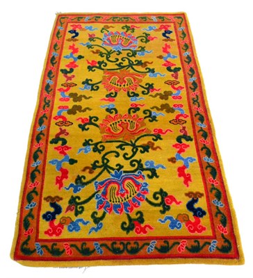 Lot 678 - Tibetan Rug The mustard field with vines around four lotus flowers enclosed by meandering vine...