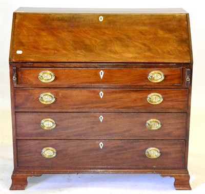 Lot 688 - A George III Mahogany Bureau, with a fitted interior and four long drawers, on ogee bracket...