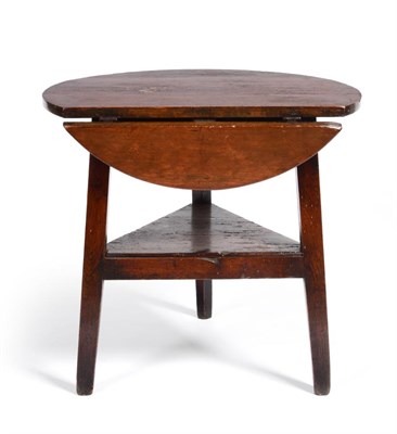 Lot 716 - A George III Pine and Oak Cricket Table, the circular top with a hinged leaf to one side, on...