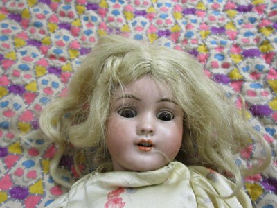 Lot 1015 - German S&H 1249 small bisque socket head doll, with blond hair wearing a floral dress