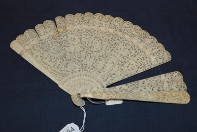 Lot 1084 - A circa 1840's Chinese carved ivory brisé fan, Qing Dynasty, the 19 inner sticks densely...
