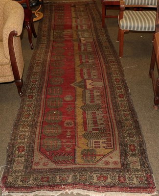 Lot 1195 - An unusual Anatolian runner, the field of stylised trees and buildings enclosed by flower head...