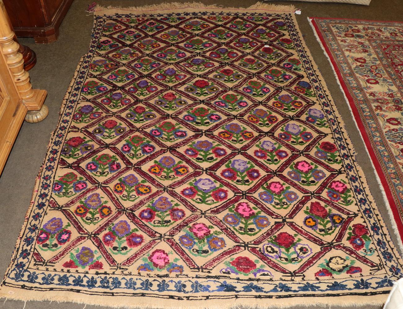 Lot 1197 - Wool carpet with natural ground, woven with a trellis of coloured flowers within a border of...