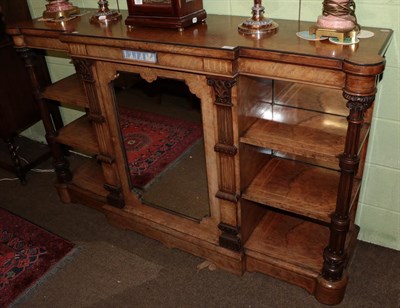 Lot 1206 - A Victorian figured walnut breakfront credenza, mirrored central door flanked by shelves, with...