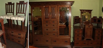 Lot 1214 - An Arts & Crafts oak six piece bedroom suite, comprising a wardrobe, the cornice above two mirrored