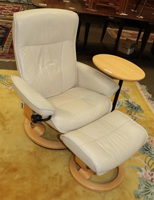 Lot 1245 - A stressless recliner chair and footstool; together with a matching beech occasional table (3)