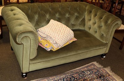 Lot 1258 - A late Victorian two-seater Chesterfield, upholstered in green buttoned velvet, 152cm wide