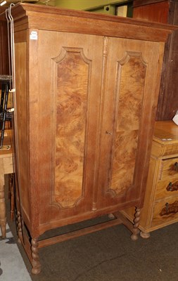 Lot 1287 - A Danish oak two door cabinet, walnut veneer panels, integral cornice, barley twist supports, 173cm