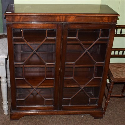 Lot 1292 - A reproduction mahogany bookcase, with glazed astragal doors, on bracket feet