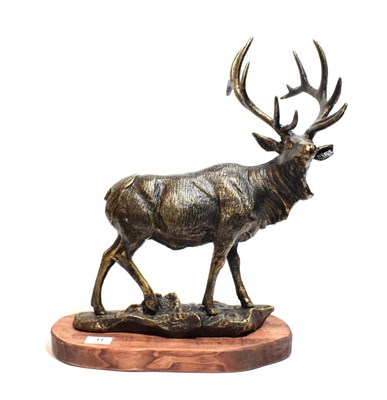 Lot 11 - A reproduction bronzed metal model of a stag, on wooden base, 47cm high