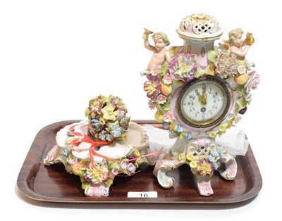 Lot 16 - A late 19th century German porcelain clock on stand, floral encrusted with twin cherubs (a.f.)