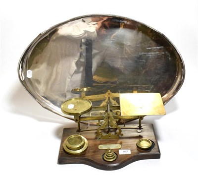 Lot 162 - A silver plated oval tray and a set of brass postal scales and weights