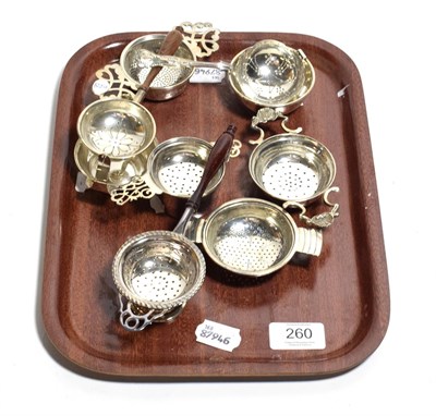 Lot 260 - Seven various tea strainers, comprising: four with conforming stand, each with differing...