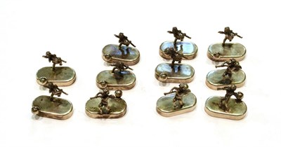 Lot 421 - A set of twelve Italian silver place-card holders, each on oval base, applied with a cast putto...