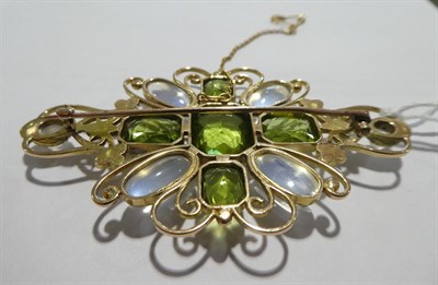 Lot 2040 - A Peridot and Moonstone Plaque Brooch, five emerald-cut peridots in a cross motif with four...