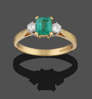 Lot 2041 - An 18 Carat Gold Emerald and Diamond Three Stone Ring, the emerald-cut emerald in a yellow four...