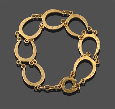 Lot 2046 - An 18 Carat Gold Horseshoe Motif Bracelet, seven horseshoe motifs chain linked, length 17cm see...