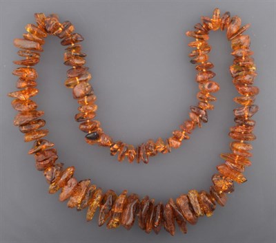Lot 2054 - An Amber Necklace, ninety-five irregular shaped and sized orangey-brown amber beads, length...