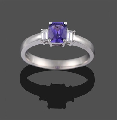 Lot 2066 - An 18 Carat White Gold Purple Sapphire and Diamond Ring, the scissor-cut sapphire within two...