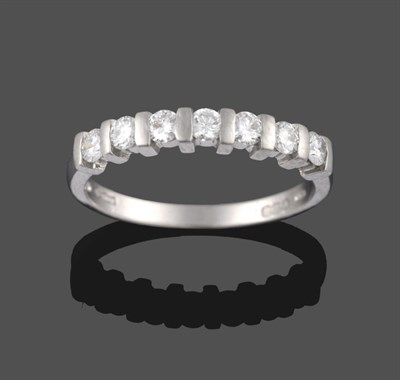 Lot 2075 - A Platinum Diamond Half Hoop Ring, the seven round brilliant cut diamonds in bar settings on a...