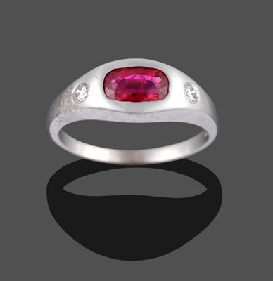 Lot 2078 - An 18 Carat White Gold Ruby and Diamond Three Stone Ring, the cushion cut ruby and two round...