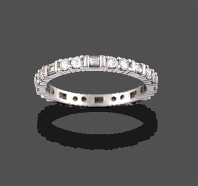 Lot 2084 - A Diamond Eternity Ring, pairs of round brilliant cut diamonds in white claw settings spaced by...