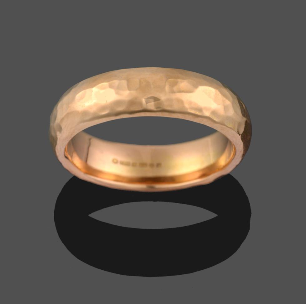 Lot 2097 - An 18 Carat Rose Gold Planished Band Ring, finger size S1/2 see illustration