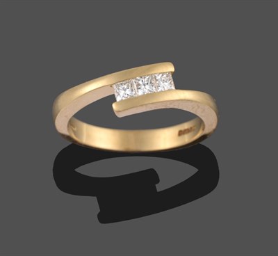 Lot 2104 - An 18 Carat Gold Princess Cut Diamond Three Stone Ring, the uniform diamonds tension set in a twist
