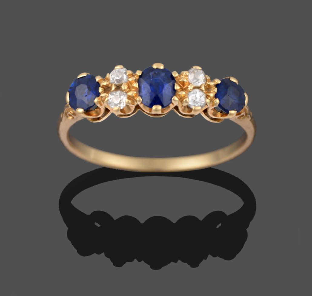 Lot 2159 - A Sapphire and Diamond Ring, an oval cut sapphire flanked by pairs of old cut diamonds to a...