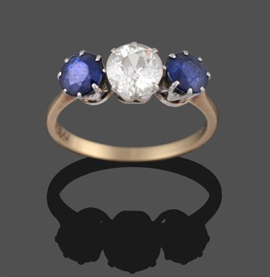 Lot 2168 - A Sapphire and Diamond Three Stone Ring, the old cut diamond flanked by two round cut sapphires...