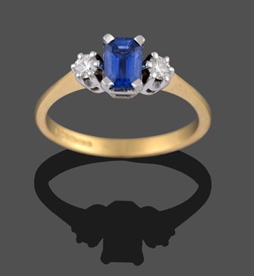 Lot 2169 - An 18 Carat Gold Sapphire and Diamond Three Stone Ring, the emerald-cut sapphire in a white...