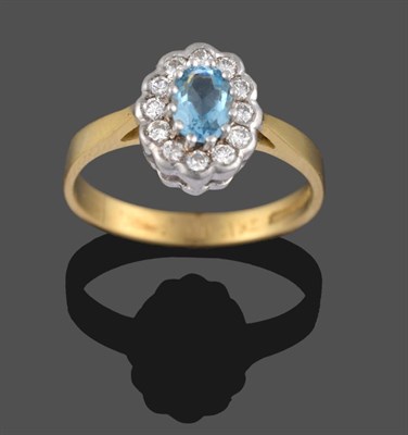 Lot 2171 - An 18 Carat Gold Aquamarine and Diamond Cluster Ring, the oval cut aquamarine in white claws...