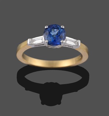 Lot 2174 - An 18 Carat Gold Sapphire and Diamond Three Stone Ring, the round mixed cut sapphire in a white...