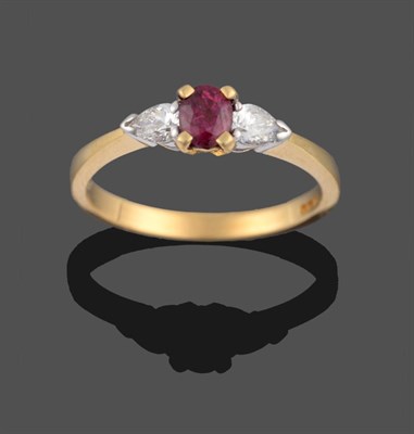 Lot 2190 - An 18 Carat Gold Ruby and Diamond Three Stone Ring, a cushion cut ruby in yellow claws sits between